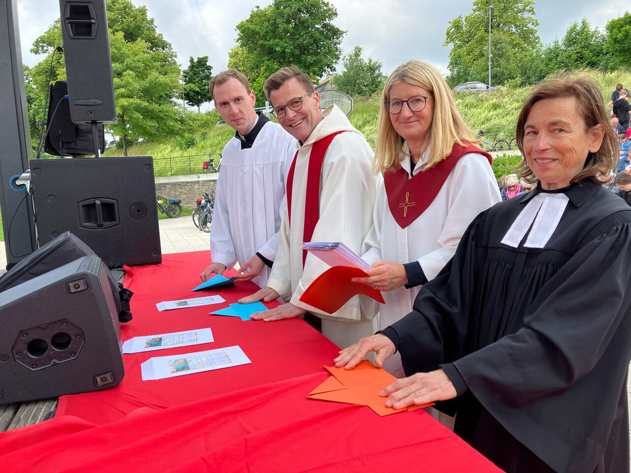 Gemeinsames Schiffchen-Falten – gegen Sorgenfalten: Pfarrer Stefan Siebert (2.v.li.) und Pfarrerin Gabi Hirsch (re.) sowie Tobias Goltsch und Nicole Laufmöller vom Pastoralteam Sundern erledigen „ihre Bastelarbeit“ auf der Bühne.